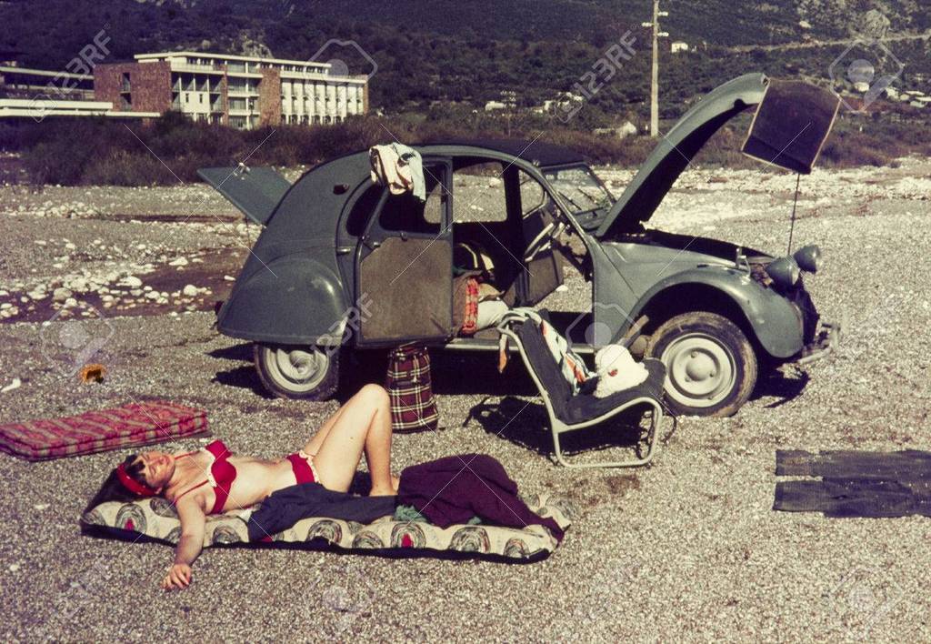 55366086-original-vintage-colour-slide-from-1960s-young-woman-relaxing-on-a-beach-with-her-car-.jpg