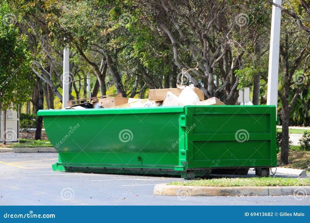 green-metal-dumpster-south-florida-painted-steel-filled-cardboard-boxes-other-trash-parking-lo...jpg