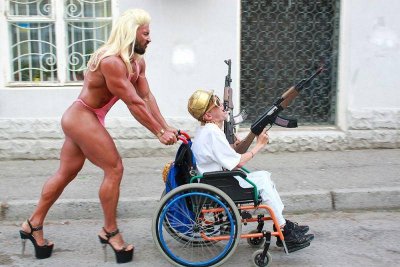 0fa5b86d3705f784dc4a3ef323228412-muscular-guy-in-drag-pushes-gun-toting-guy-in-wheelchair.jpg